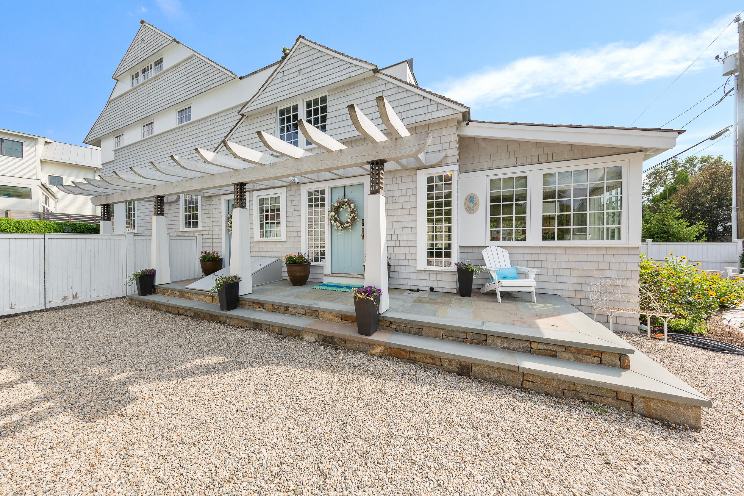 10 Juniper Road Rowayton, CT 06853 - Photo 27 of 28 a view of a white house with a large windows and plants