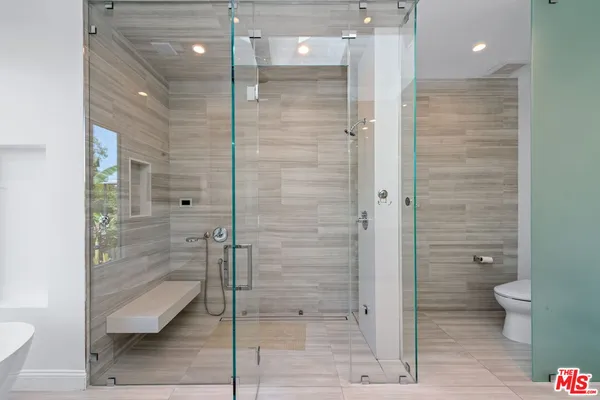 a bathroom with a sink toilet a mirror and shower