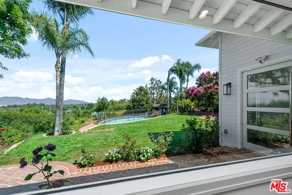 a front view of a house with a yard and potted plants