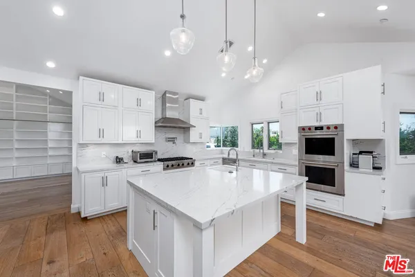 a kitchen with stainless steel appliances a stove sink and cabinets