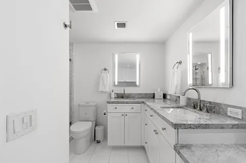 a kitchen with granite countertop white cabinets sink and stainless steel appliances
