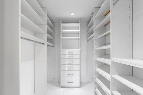 a bedroom with two beds and large windows