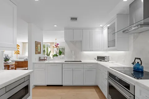a kitchen with white cabinets stainless steel appliances and sink