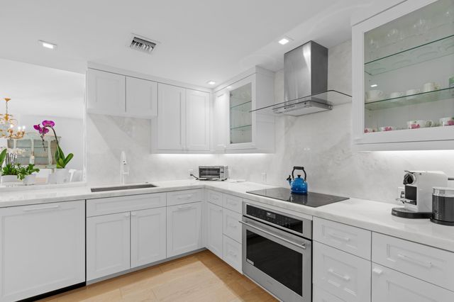 a kitchen with a sink stove top oven and cabinets