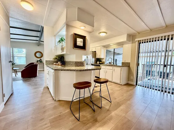 a kitchen with stainless steel appliances granite countertop a stove a sink dishwasher and a refrigerator with wooden floor