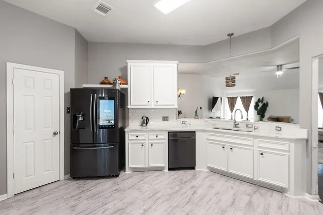 a kitchen with stainless steel appliances a sink a stove a refrigerator and cabinets