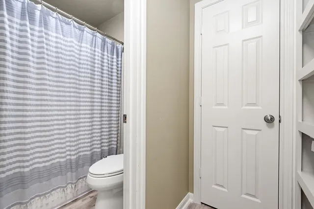 a white toilet sitting next to a shower curtain