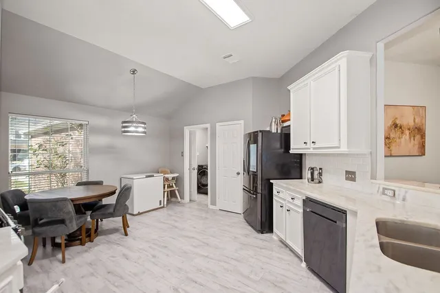 a kitchen with stainless steel appliances kitchen island granite countertop a sink cabinets and wooden floor