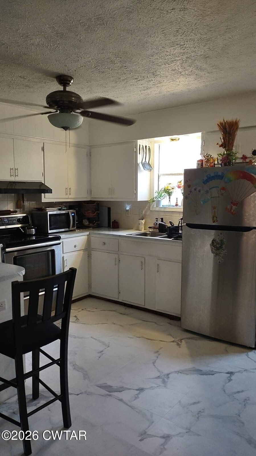 195 Ridge Road Medina, TN 38355 - Photo 8 of 14 a kitchen with stainless steel appliances a sink a stove a refrigerator cabinets and dining table