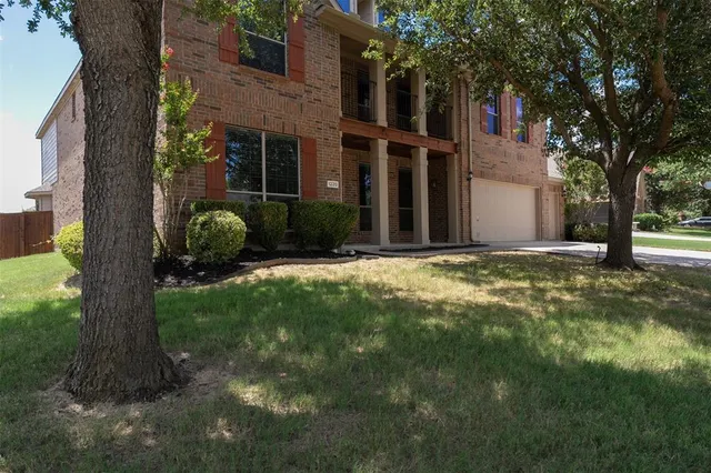 a view of a house with a tree in a yard