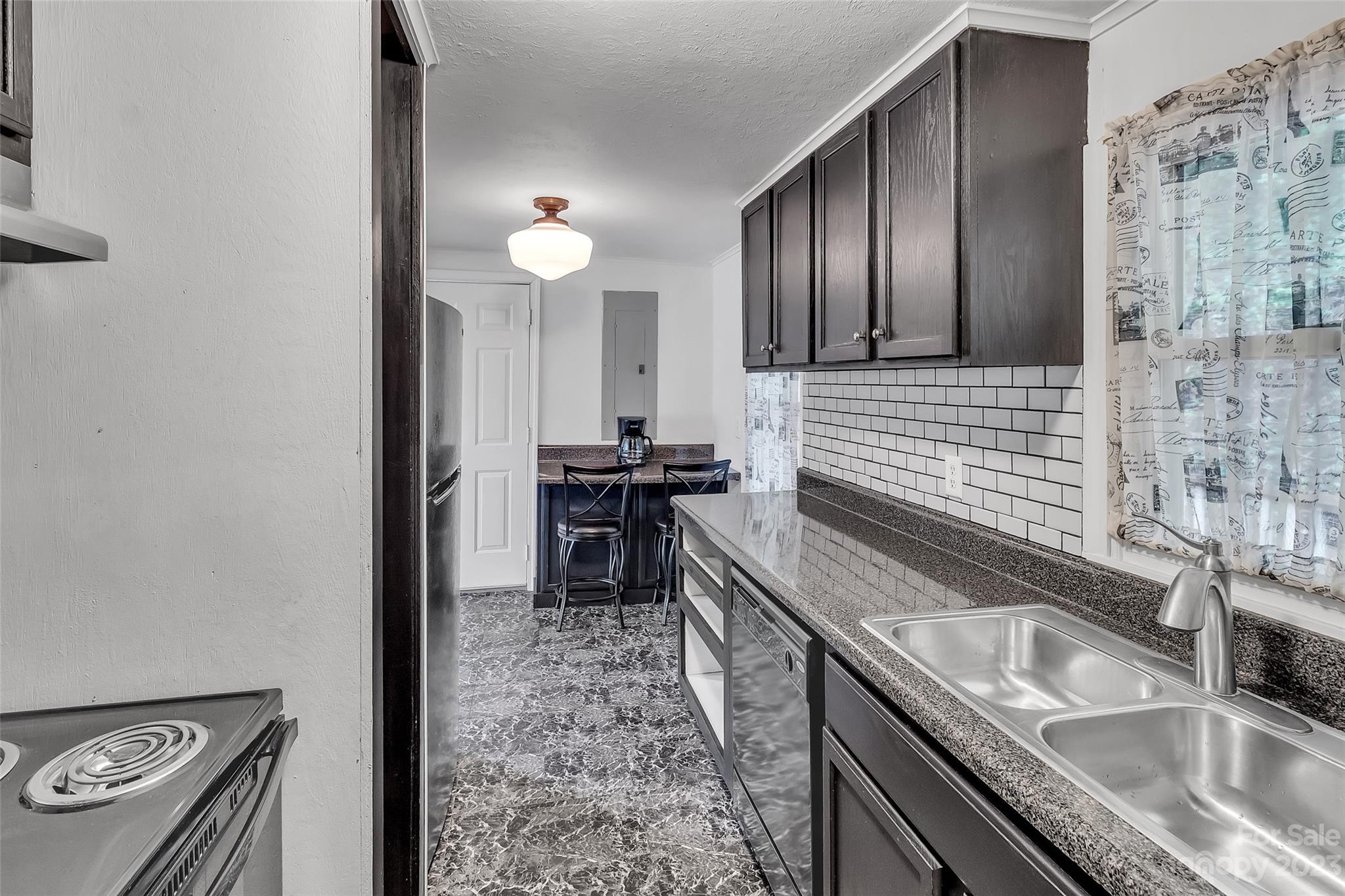 9 Alzena Road Sylva, NC 28779 - Photo 5 of 25 a kitchen with granite countertop a sink stainless steel appliances a counter space and cabinets
