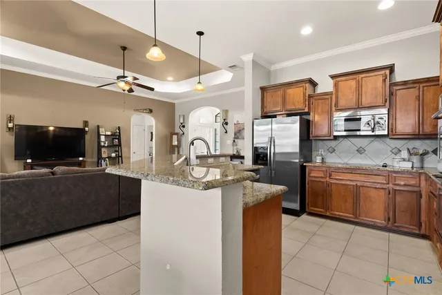a large kitchen with stainless steel appliances granite countertop a sink and a microwave