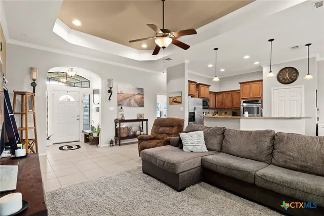 a living room with furniture kitchen view and a chandelier