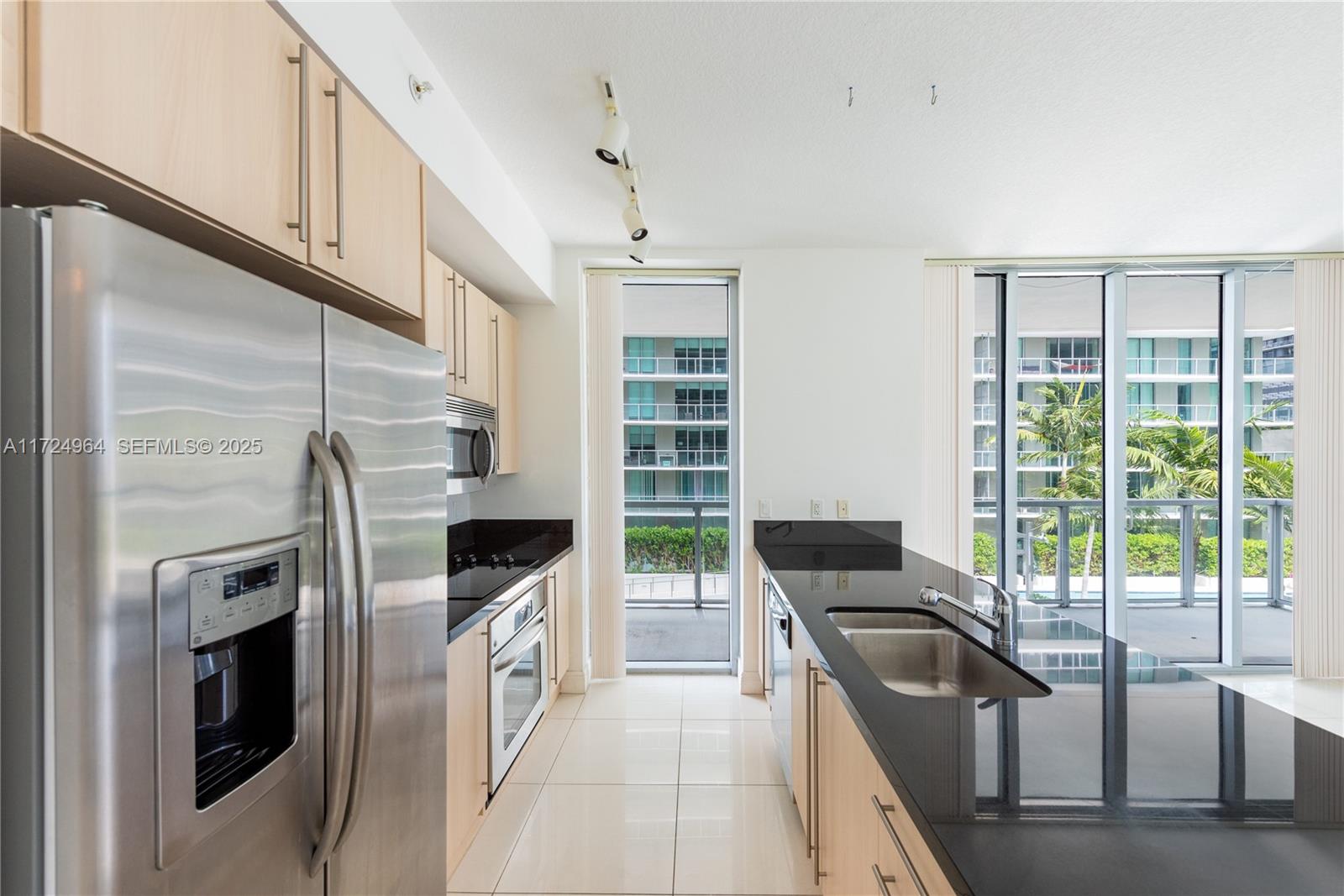 79 Southwest 12th Street, Unit 1107S Miami, FL 33130 - Photo 6 of 26 a kitchen with a stove a fridge and a sink