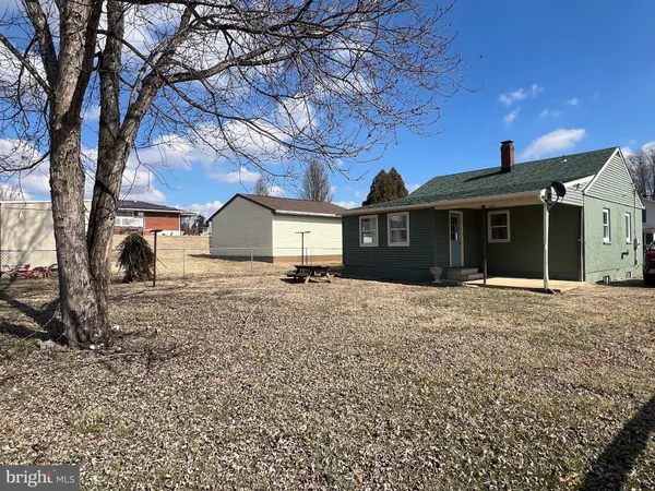 a front view of a house with a yard fountain and a fire pit