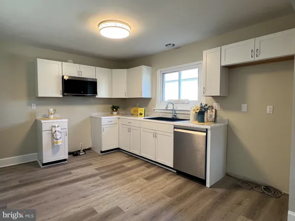 a kitchen with a sink cabinets and wooden floor