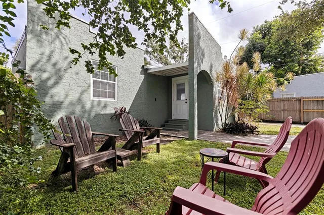a view of a patio with table and chairs with wooden fence and plants