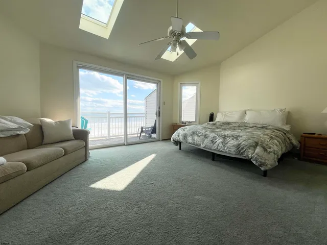 a bedroom with a bed couch chandelier and window