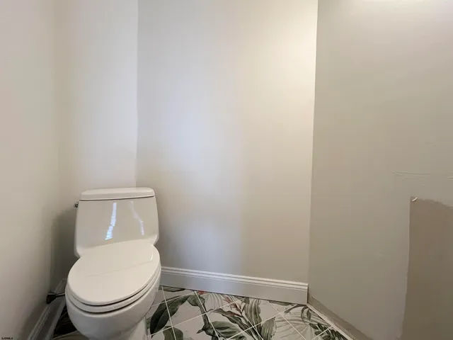 a white toilet sitting next to a small window