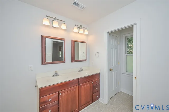 a spacious bathroom with a double vanity sink and a mirror