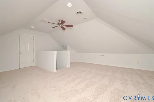 an empty room with a ceiling fan and carpet