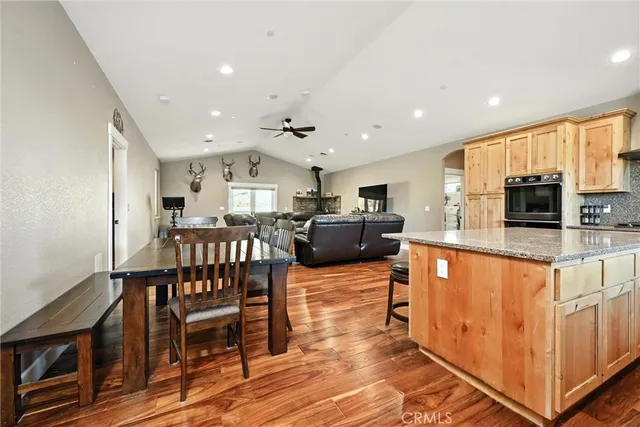 a kitchen with stainless steel appliances granite countertop a refrigerator a sink dishwasher a stove and a sink with wooden floor