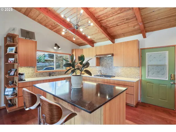 a kitchen with stainless steel appliances granite countertop a sink a counter space and a window