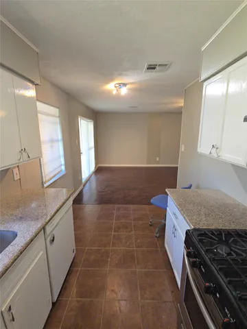 a bathroom with a granite countertop sink a toilet and a mirror