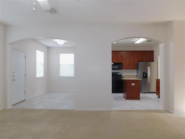 a view of a kitchen with wooden cabinets and a window