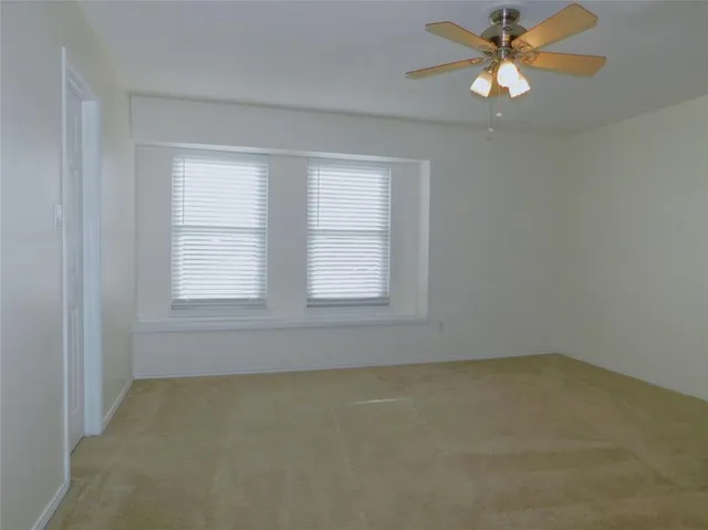 an empty room with a chandelier fan