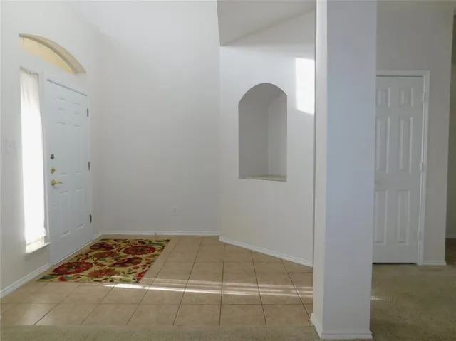 a view of a room with a chandelier fan and windows
