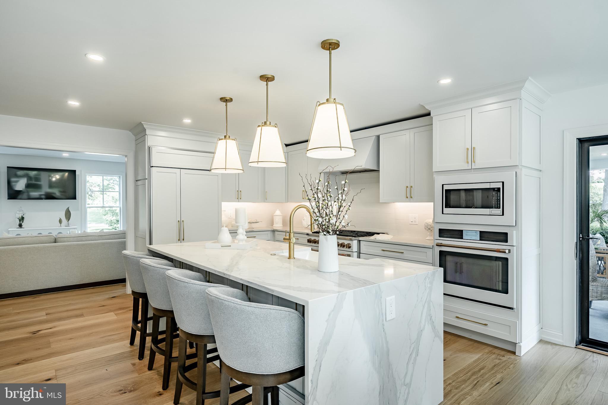 2058 Waterloo Road Berwyn, PA 19312 - Photo 16 of 46 a kitchen with stainless steel appliances kitchen island granite countertop a table chairs stove and white cabinets