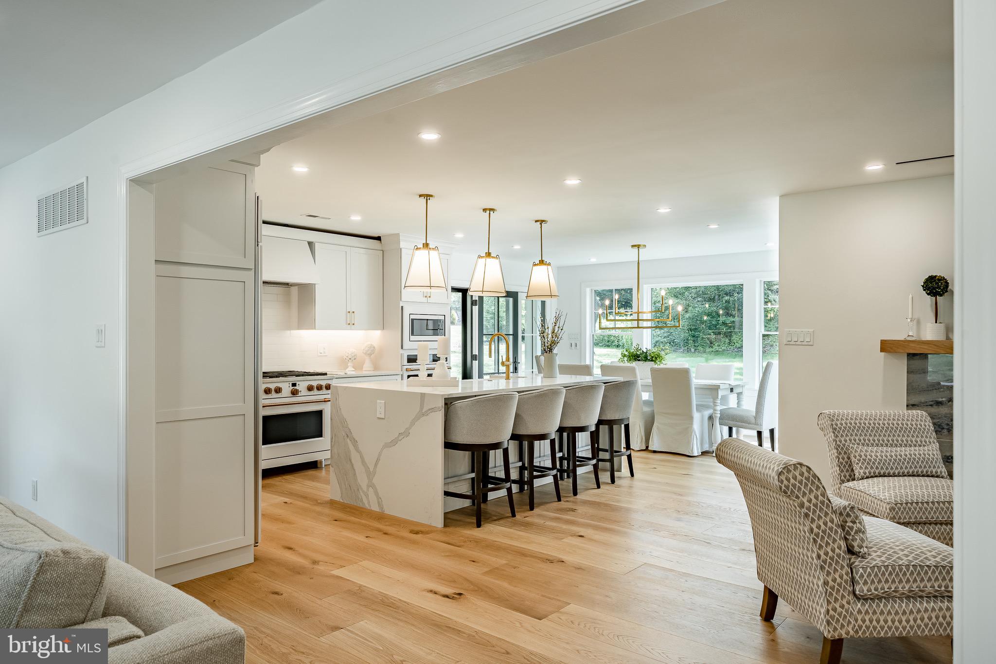 2058 Waterloo Road Berwyn, PA 19312 - Photo 19 of 46 a kitchen with stainless steel appliances kitchen island granite countertop a refrigerator a stove a dining table and chairs with wooden floor
