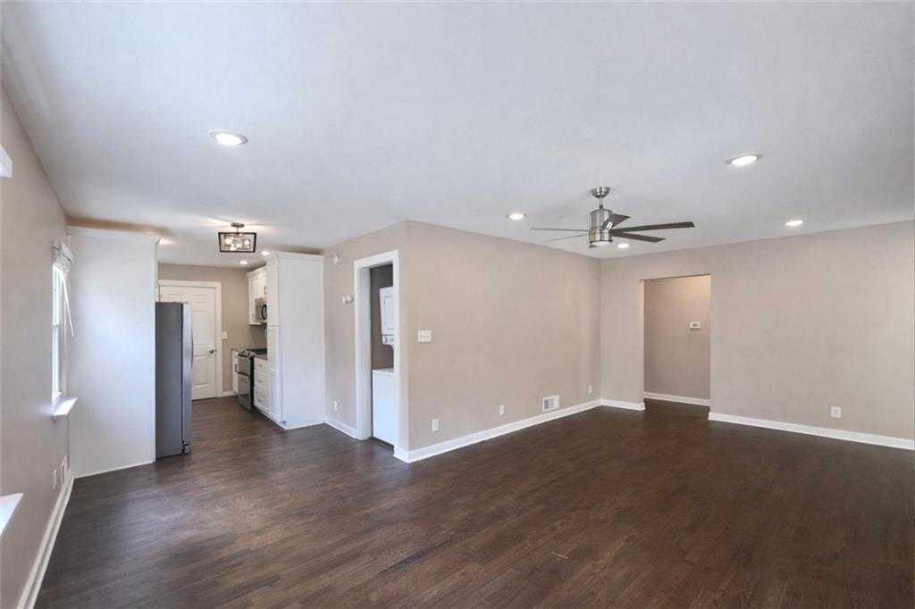 1291 Lorenzo Drive Southwest Atlanta, GA 30310 - Photo 5 of 20 a view of an empty room with wooden floor and a ceiling fan