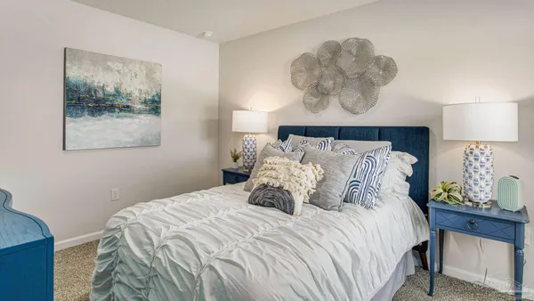 a bedroom with a bed and a painting on the wall