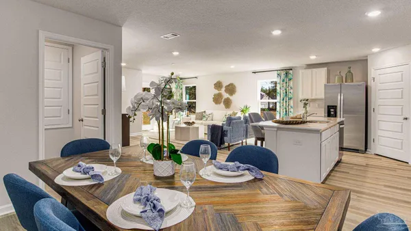 a view of a dining room with furniture a kitchen and chandelier