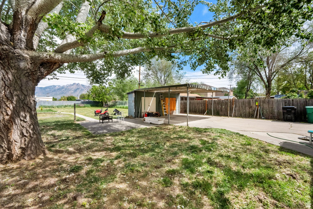 4635 Box Elder Street Murray, UT 84107 - Photo 19 of 21 Fenced backyard with a patio area and an outbuilding