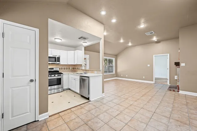 a large white kitchen with a sink and cabinets
