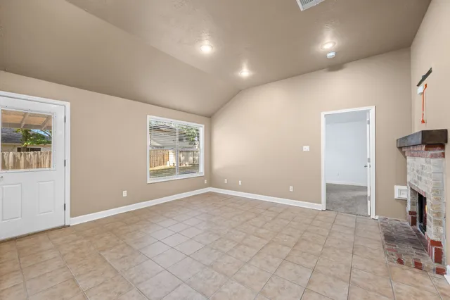 an empty room with fireplace and windows