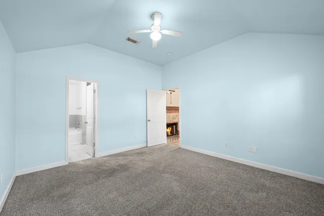 a view of an empty room and chandelier fan