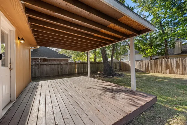 a patio of a house with wooden floor yard and outdoor seating