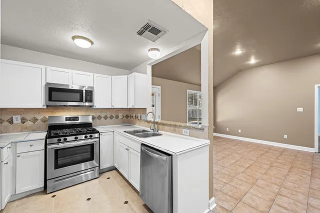 a kitchen with a sink stove and microwave