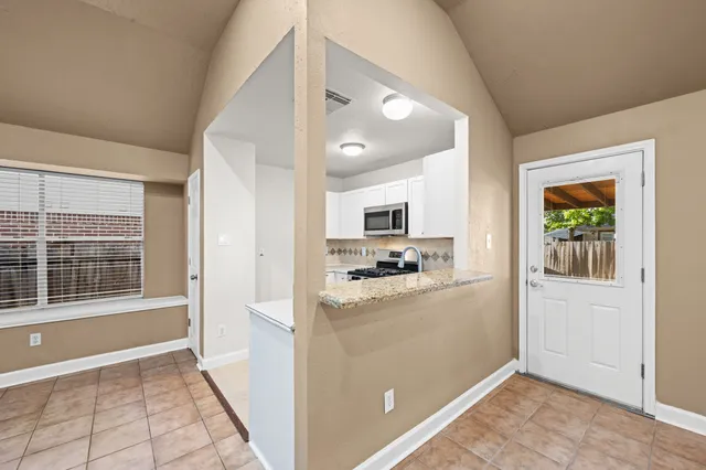 a kitchen with stainless steel appliances a refrigerator a stove a sink and a window