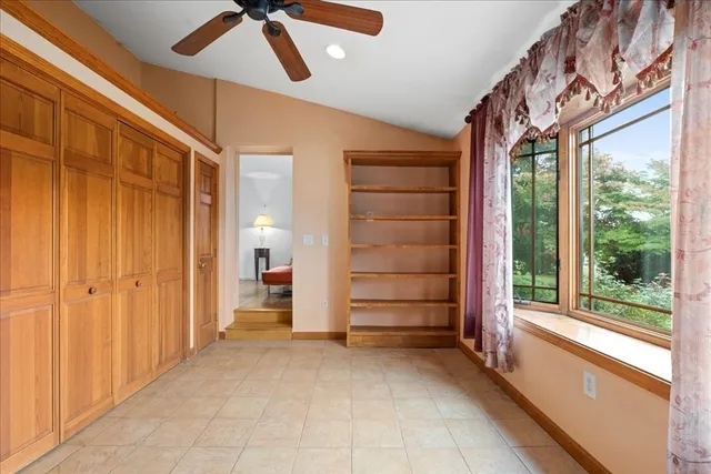 a view of empty room with a ceiling fan and window