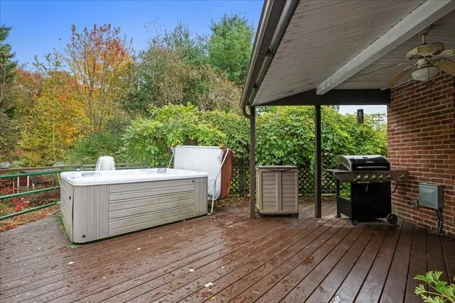 a view of a roof deck with table and chairs a barbeque with wooden floor and fence