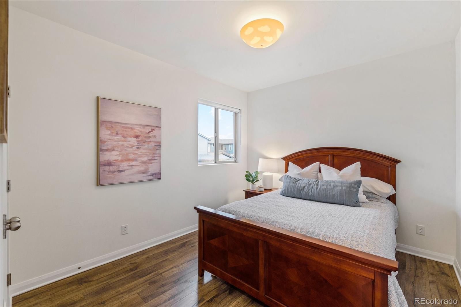 6731 Raritan Drive Denver, CO 80221 - Photo 26 of 40 a bedroom with a bed and a potted plant