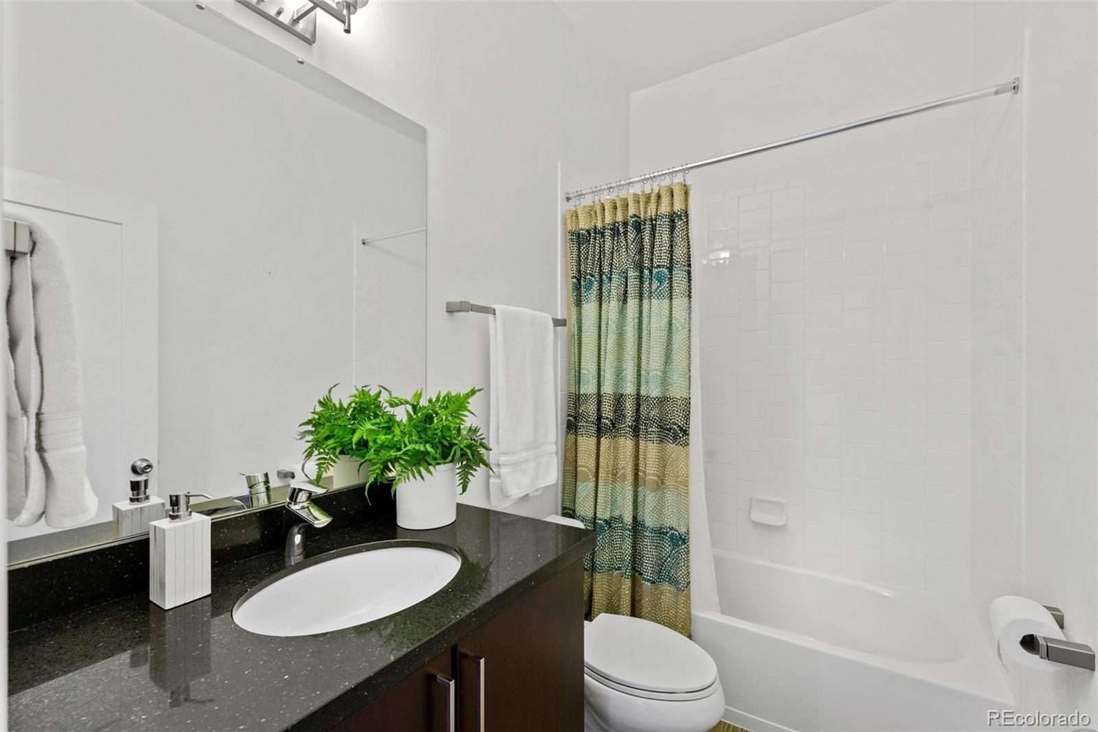 6731 Raritan Drive Denver, CO 80221 - Photo 32 of 40 a bathroom with a granite countertop sink and a mirror