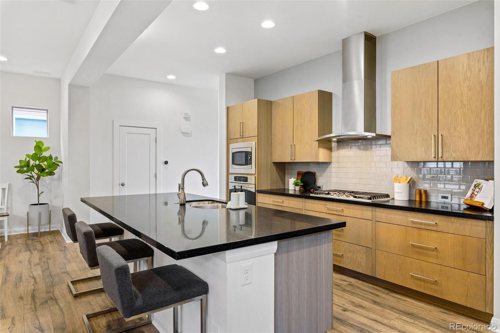 6731 Raritan Drive Denver, CO 80221 - Photo 10 of 40 a kitchen with granite countertop a sink a stove cabinets counter space and dining table