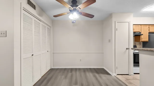 wooden floor in an empty room with a kitchen