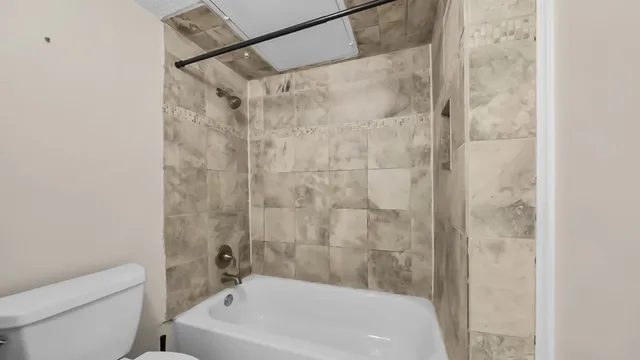 a bathroom with a granite countertop sink mirror and a bathtub